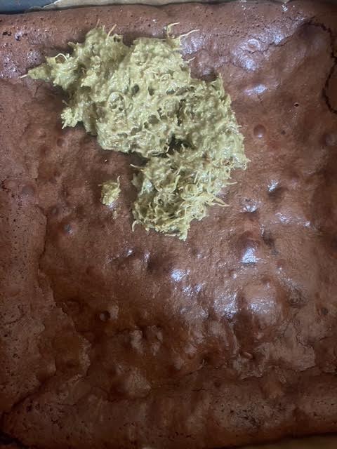 Pistachio Kataifi mixture being added on top of brownies