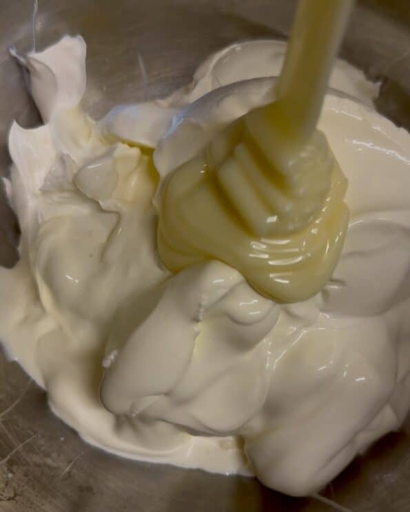 Cream cheese, condensed milk and thick double cream in bowl