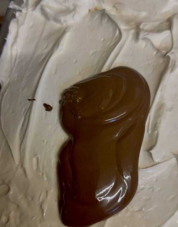 Chocolate spread being spread on top of Cream