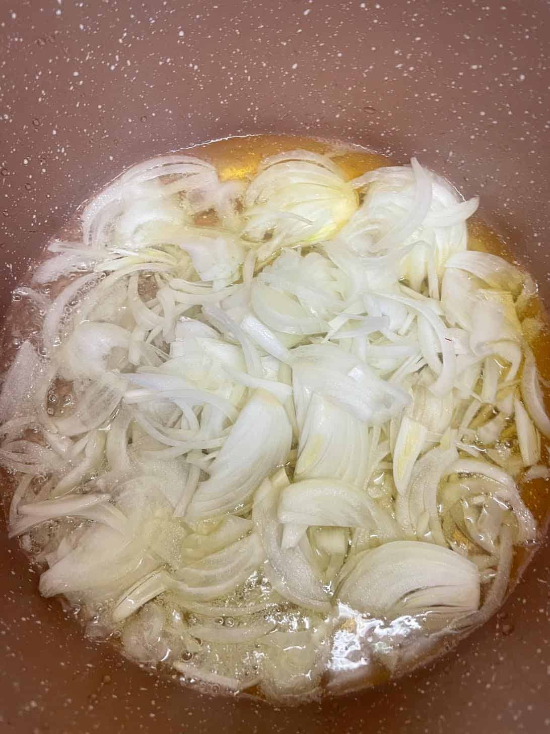 Authentic slow cooked Chicken Haleem Sliced onions in pot