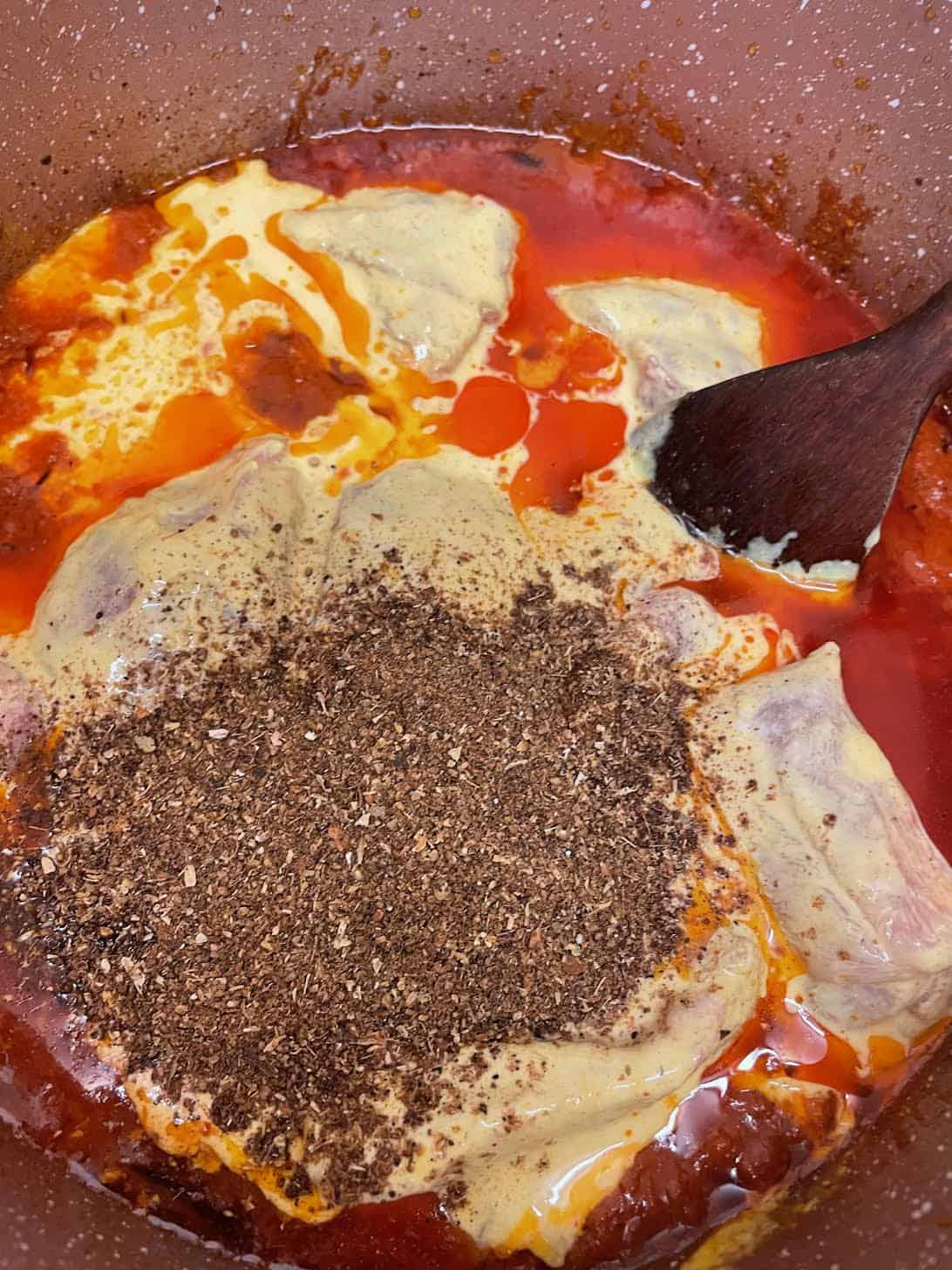 Authentic slow cooked Chicken Haleem Haleem Masala added to chicken in pot