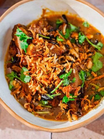 Nihari in a bowl with toppings