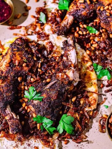 Musakkan chicken on naan with pine nuts and onions