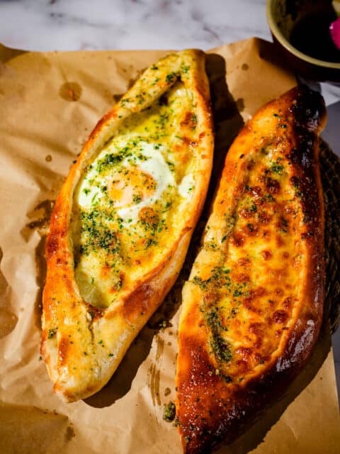 Baked stuffed bread with egg, herbs, and melted cheese, served hot at Tiffin And Tea. Perfect for br.