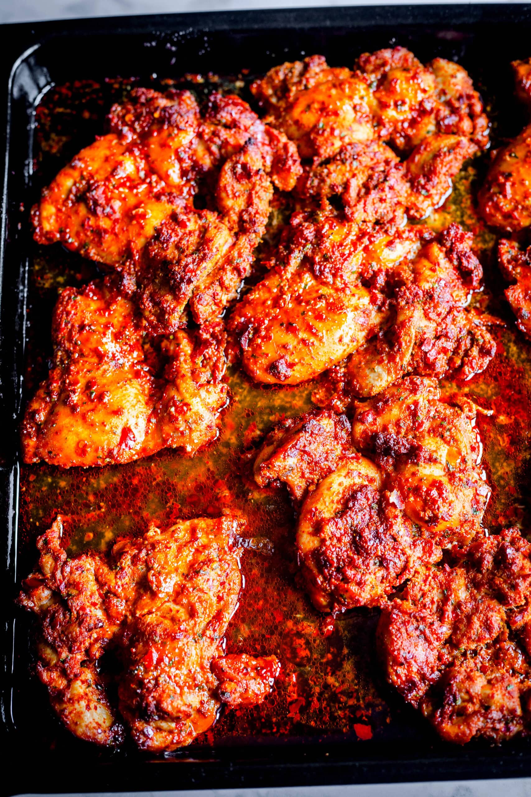 Harissa Chicken Thighs (Easy Oven-Baked Recipe) Harissa thighs in tray