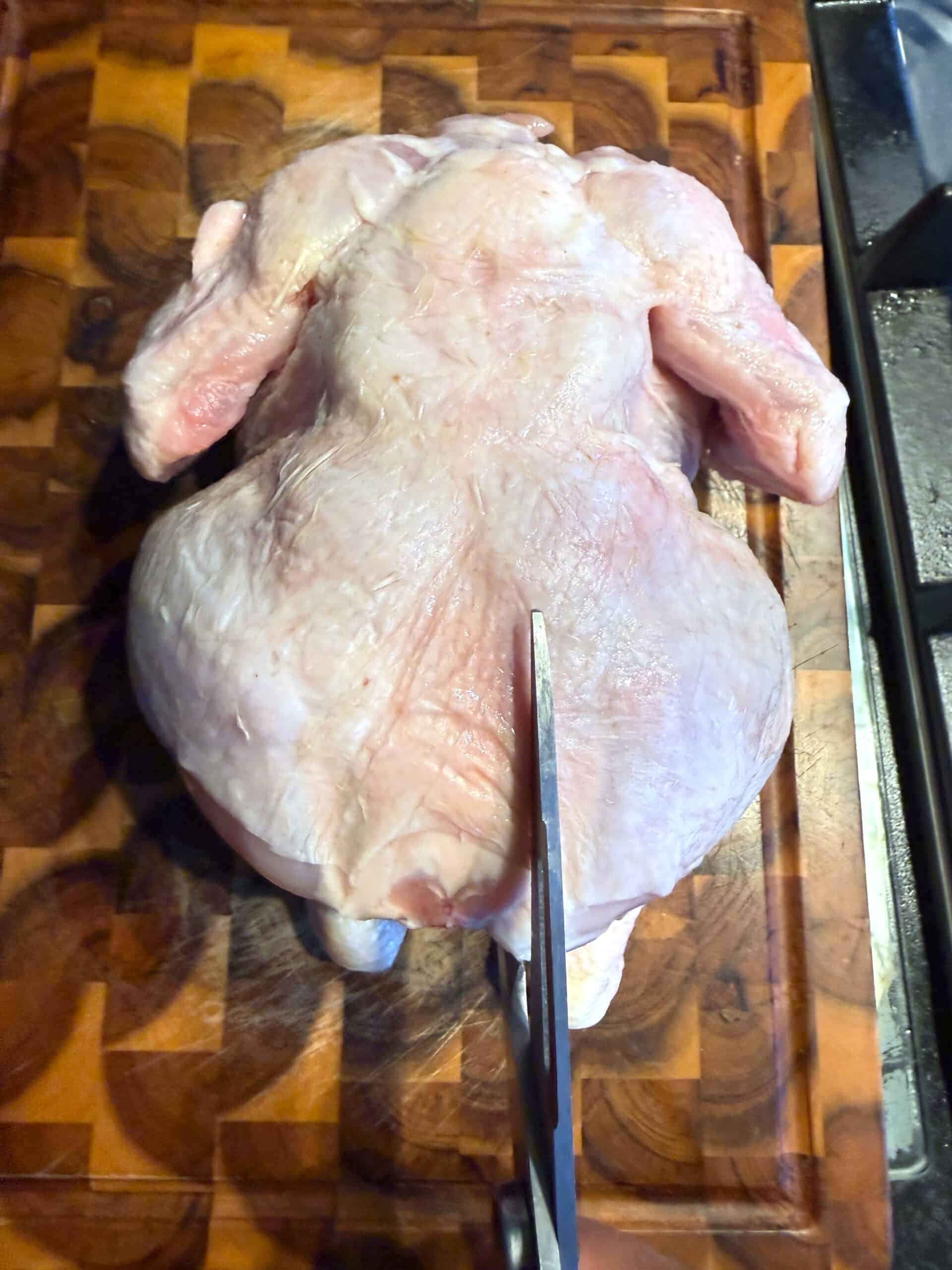 Shawarma Spatchcock Roast Chicken (Easy Middle Eastern Roast Chicken) Whole Chicken with scissors near the spine