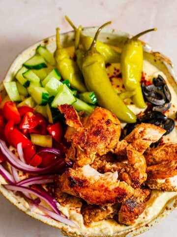 Chicken in a bowl with hummus and salad