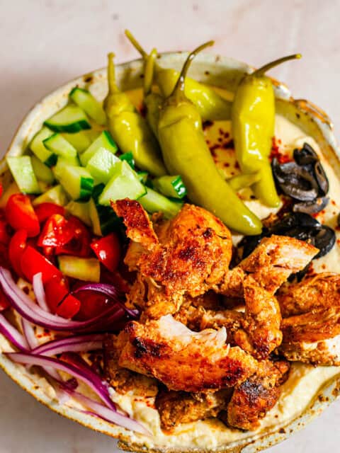 Chicken in a bowl with hummus and salad