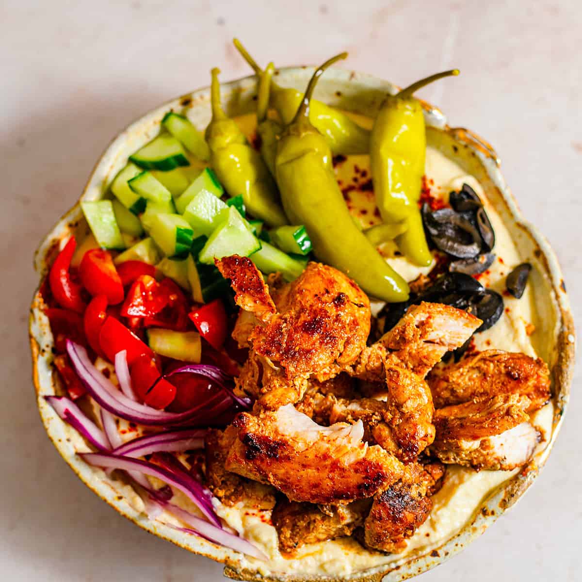 Chicken in a bowl with hummus and salad