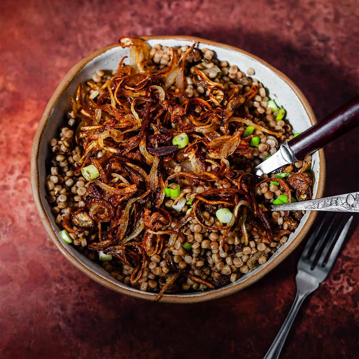 Maftoul with crispy onions in bowl