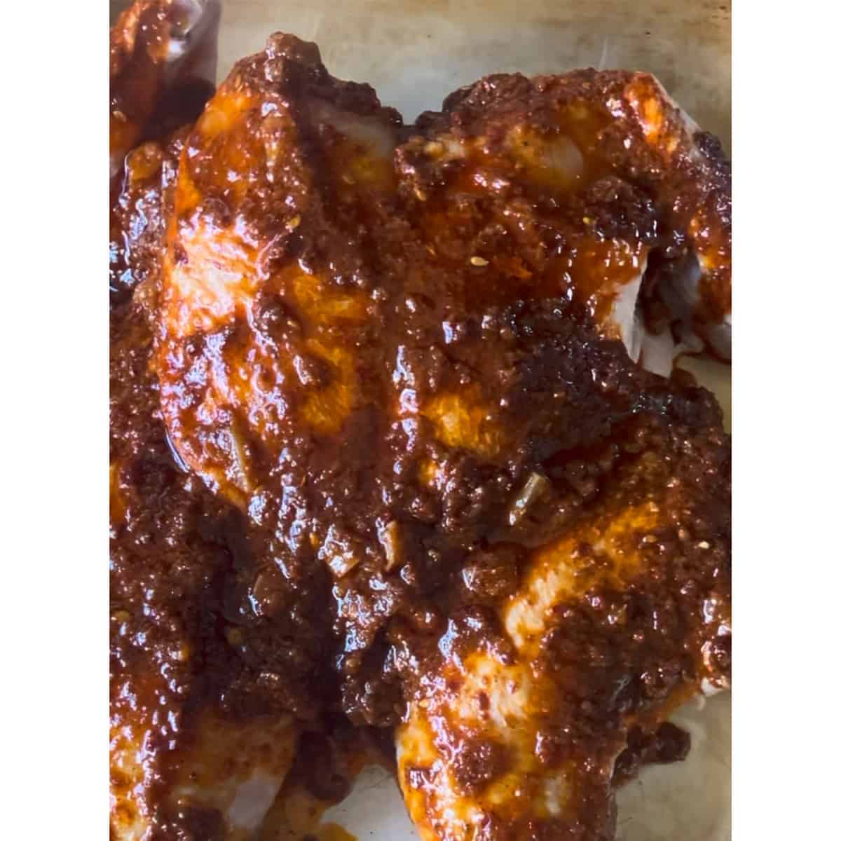 Harissa Spatchcock Chicken with Preserved Lemon Marinaded chicken on tray