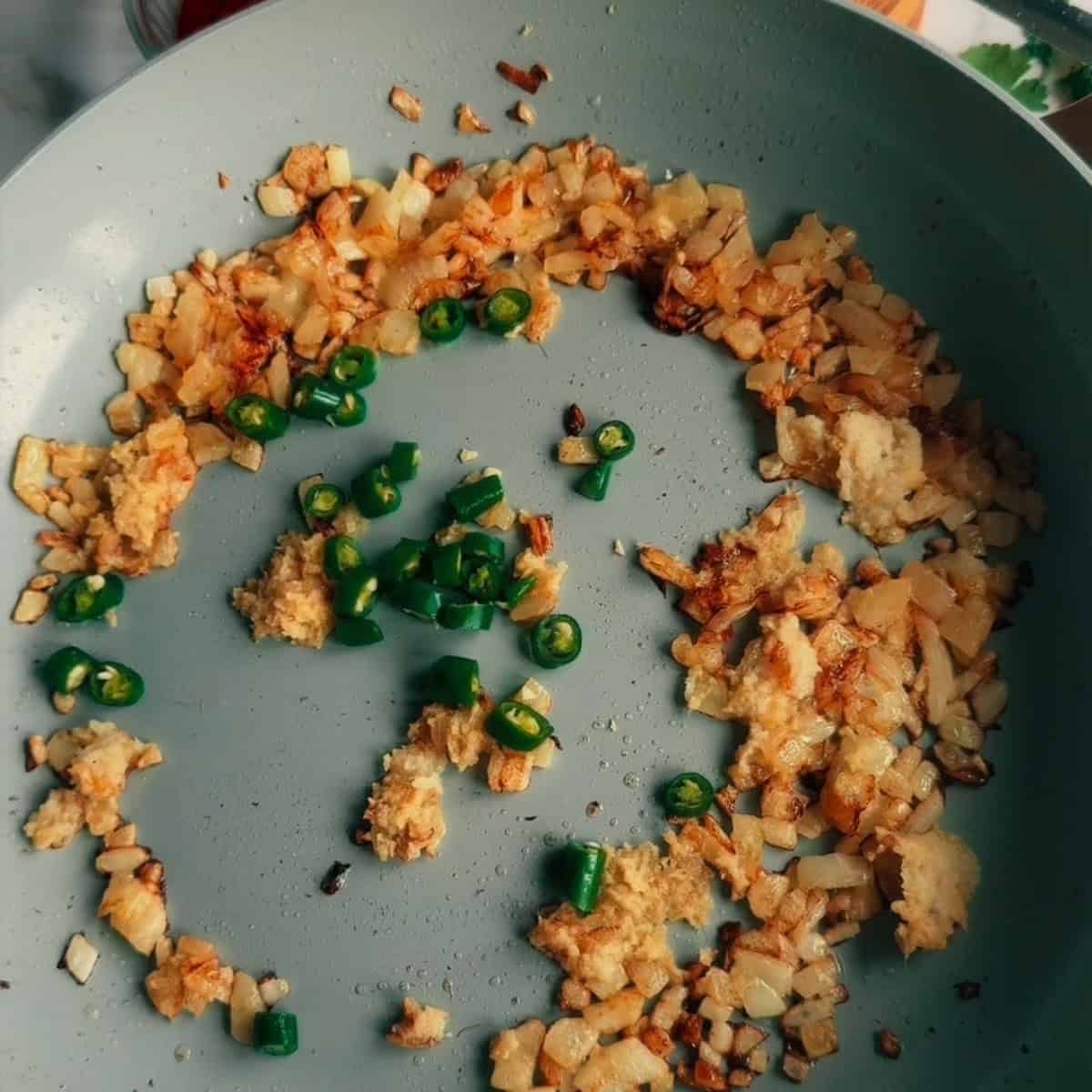 Onions, ginger, garlic and green chillies in pan