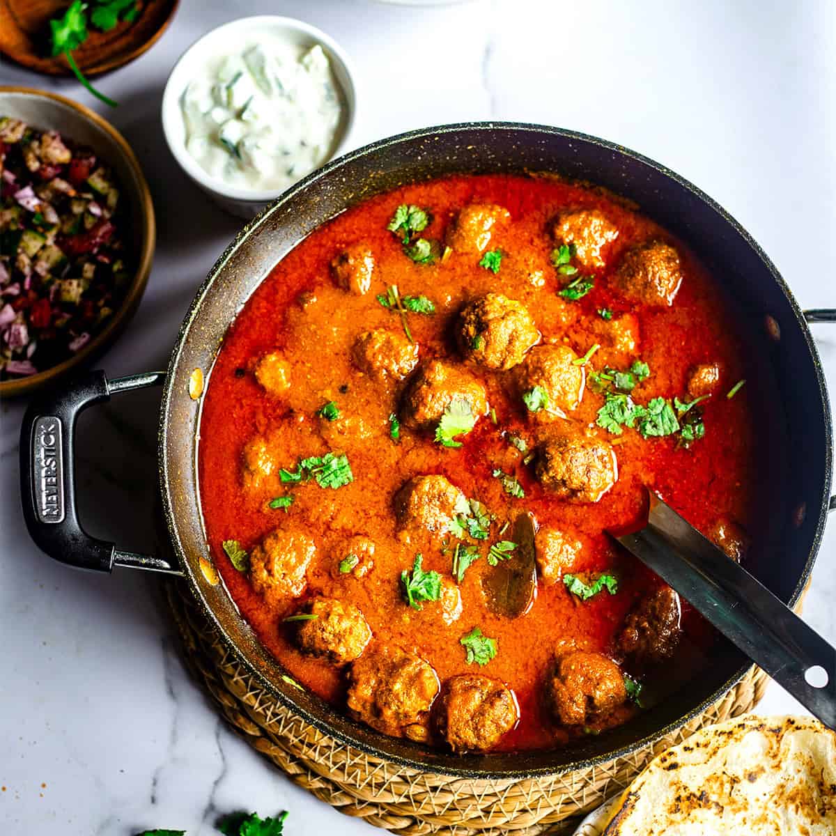 Lamb Kofta Curry (Tender Lamb Meatballs Curry) Kofta curry in pot with salads and chapatti to side