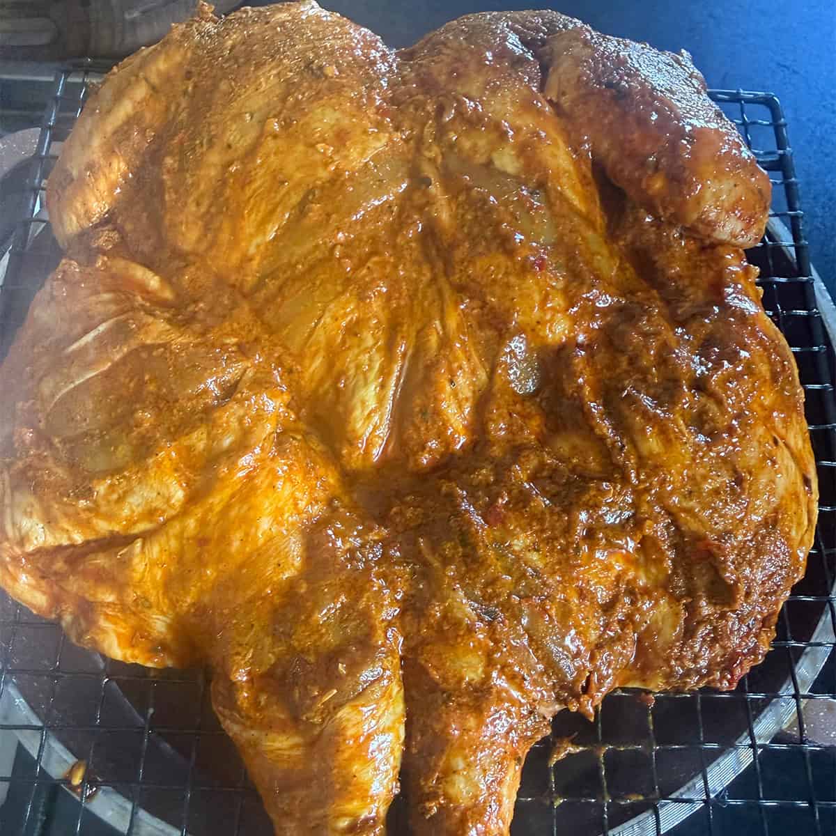 Marinaded chicken over pot on rack