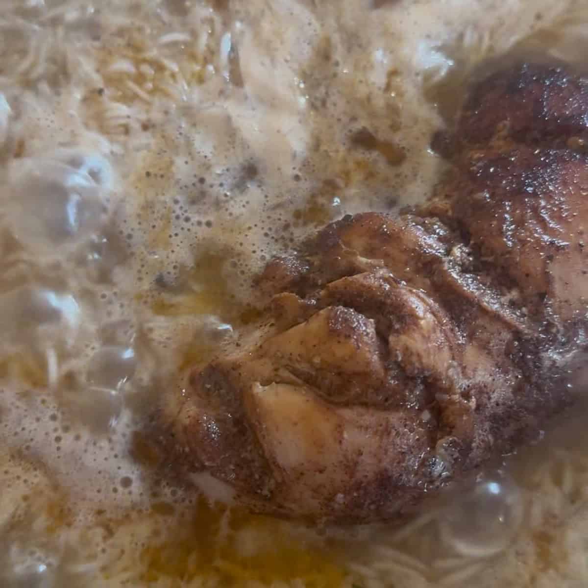 Chicken added to rice in pot