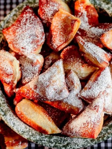 Mandazi in dish with icing sugar on top